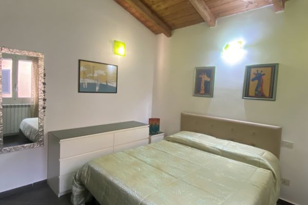 Camera con letto matrimoniale della casa vacanza una giraffa a roma, controsoffitto in legno